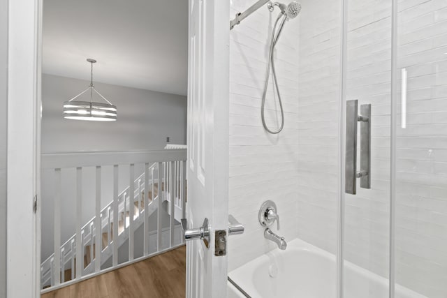 bathroom featuring bath / shower combo with glass door and hardwood / wood-style floors