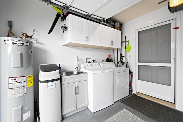 clothes washing area with washing machine and clothes dryer, electric water heater, cabinets, and sink