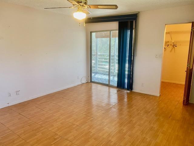 unfurnished room featuring a textured ceiling, ceiling fan, and light hardwood / wood-style flooring