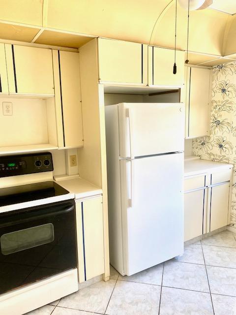 kitchen with white appliances and light tile patterned floors