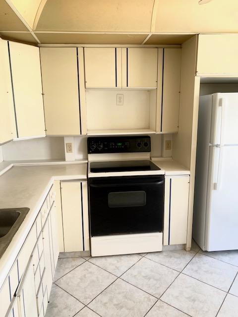 kitchen with light tile patterned floors and white appliances