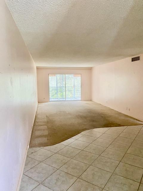 carpeted empty room with a textured ceiling