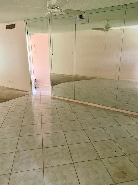 spare room with ceiling fan and tile patterned floors