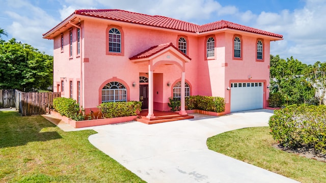 mediterranean / spanish house featuring a garage and a front yard