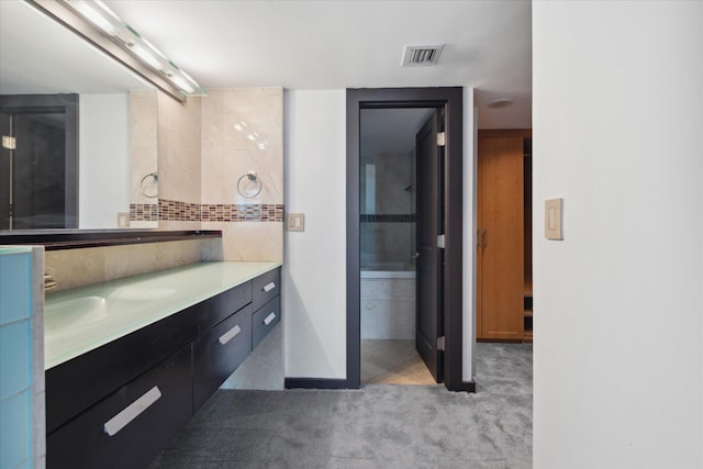 bathroom featuring visible vents, backsplash, and vanity