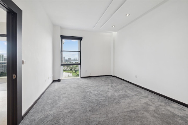 carpeted spare room featuring recessed lighting and baseboards