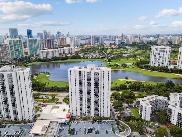 drone / aerial view featuring a water view, golf course view, and a city view