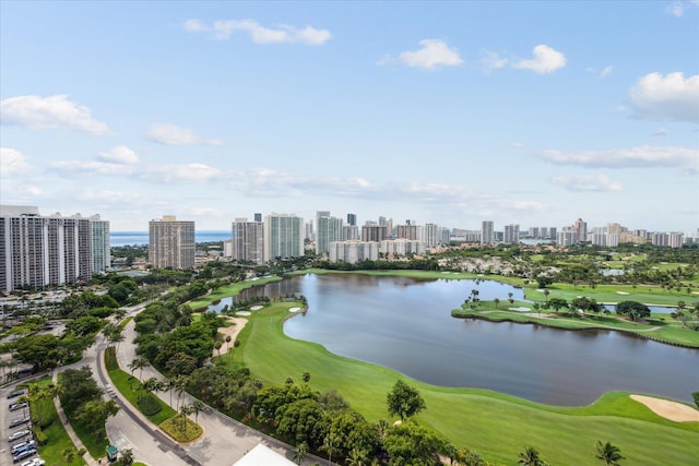 drone / aerial view featuring a view of city, a water view, and golf course view