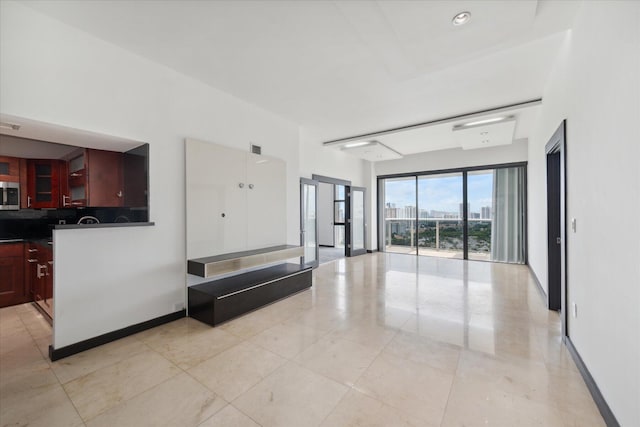 living room featuring a city view, visible vents, baseboards, and light tile patterned floors