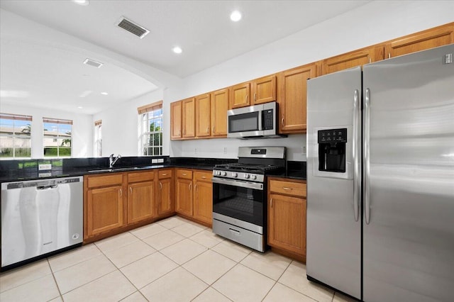 kitchen with stainless steel appliances, sink, and light tile patterned floors