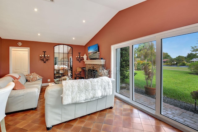 tiled living room with lofted ceiling and a stone fireplace