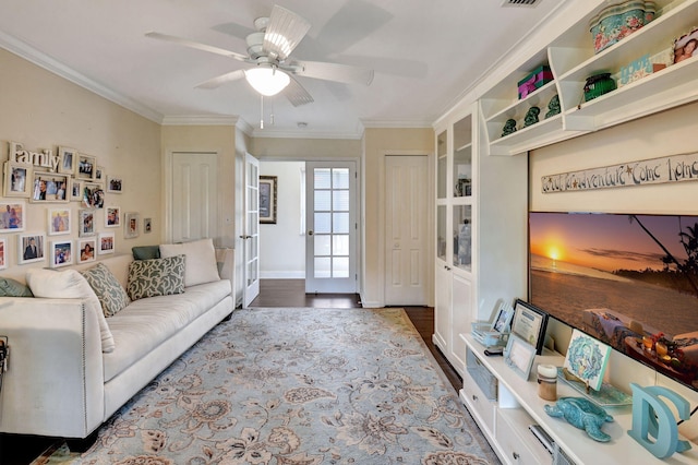 living room featuring ceiling fan, wood-type flooring, and crown molding