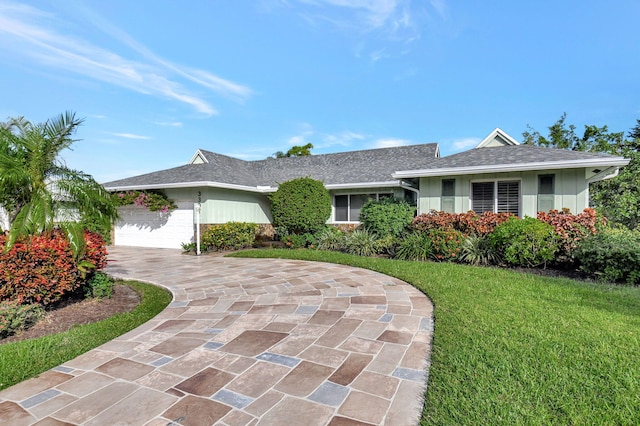 ranch-style home with a garage and a front lawn