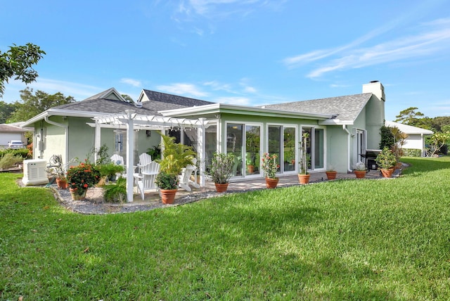 back of property featuring a pergola and a yard