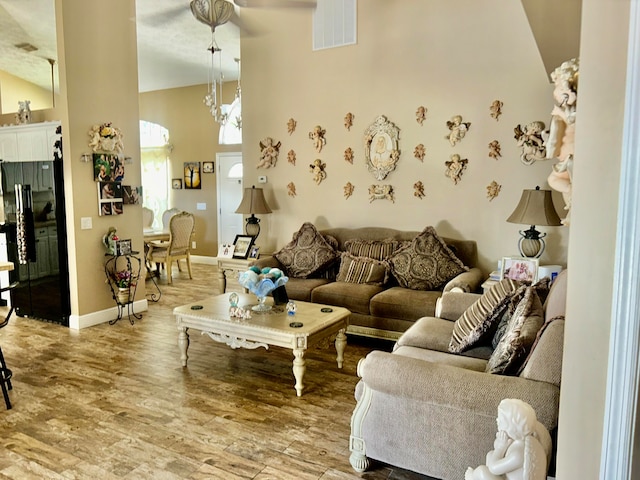 living room with high vaulted ceiling and hardwood / wood-style flooring