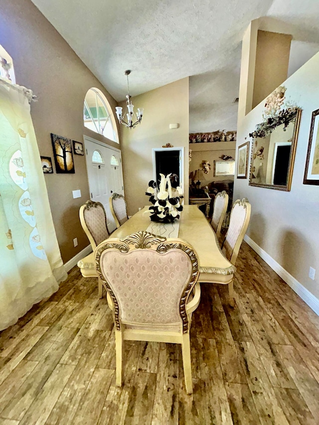 dining room featuring lofted ceiling, a notable chandelier, and hardwood / wood-style flooring