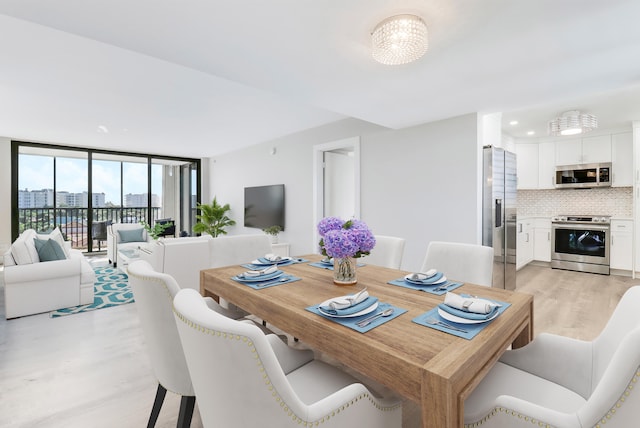 dining room featuring light hardwood / wood-style flooring, a notable chandelier, and expansive windows