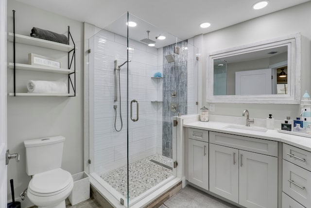 bathroom featuring toilet, an enclosed shower, and vanity