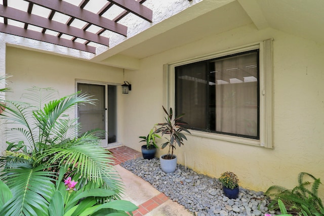 property entrance with a pergola