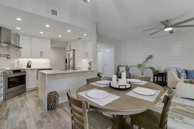 dining room with sink, ceiling fan, and light hardwood / wood-style flooring