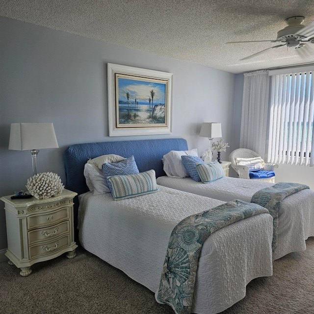 bedroom featuring ceiling fan, a textured ceiling, and dark carpet