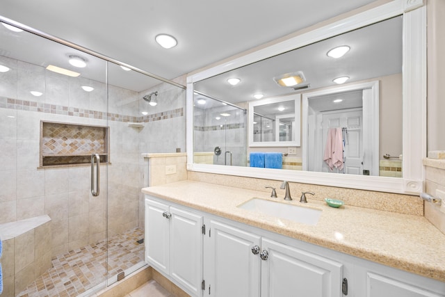 bathroom featuring walk in shower and vanity