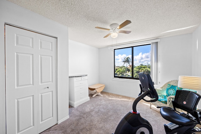 carpeted office featuring ceiling fan and a textured ceiling