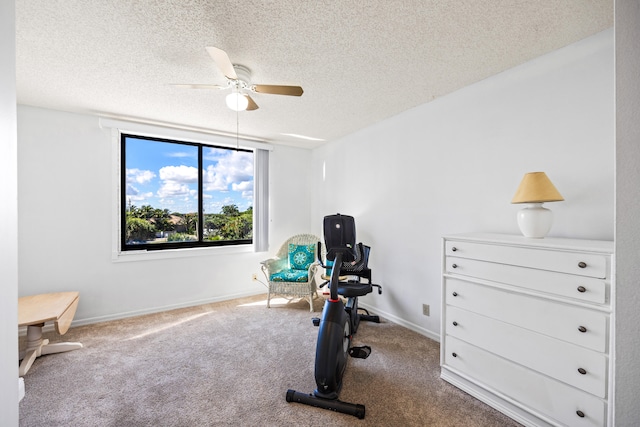 exercise area featuring a textured ceiling, carpet flooring, and ceiling fan