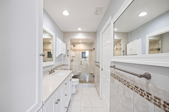 bathroom featuring vanity, toilet, tile patterned floors, and a shower with door