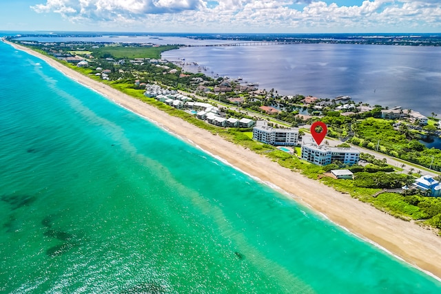 bird's eye view featuring a water view and a beach view