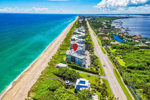 drone / aerial view featuring a water view and a view of the beach