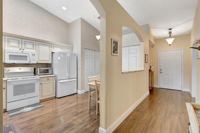 kitchen featuring white appliances, light hardwood / wood-style flooring, decorative backsplash, and hanging light fixtures