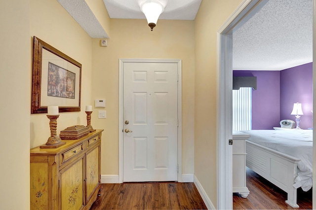 entryway featuring dark wood-type flooring and a textured ceiling