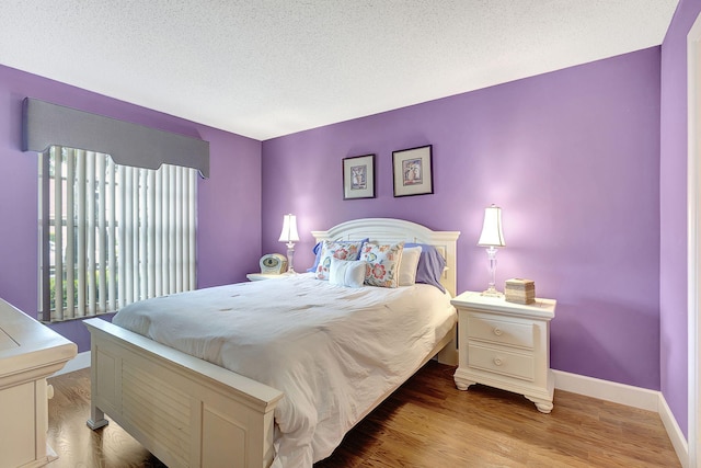 bedroom featuring a textured ceiling and hardwood / wood-style flooring