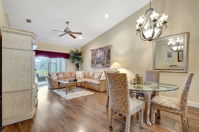 dining space with high vaulted ceiling, ceiling fan with notable chandelier, and wood-type flooring