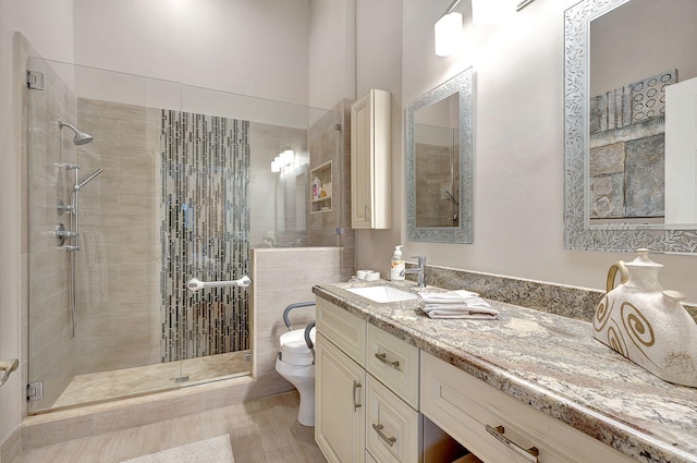 bathroom featuring vanity, toilet, hardwood / wood-style flooring, and a shower with door