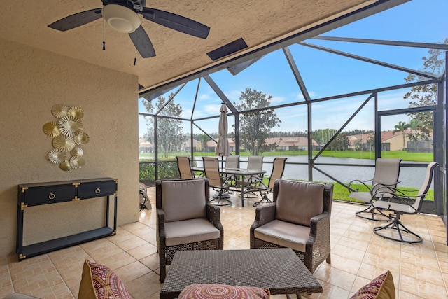 view of patio with a lanai, a water view, and ceiling fan