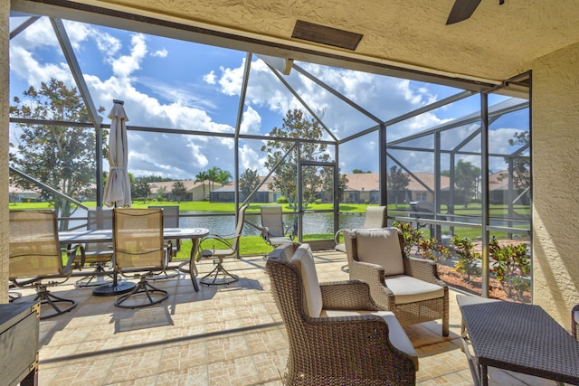 view of patio featuring a lanai and a water view