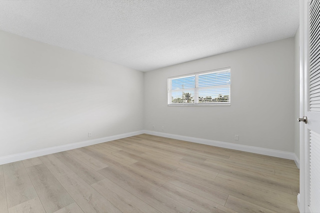 unfurnished room featuring light hardwood / wood-style floors and a textured ceiling