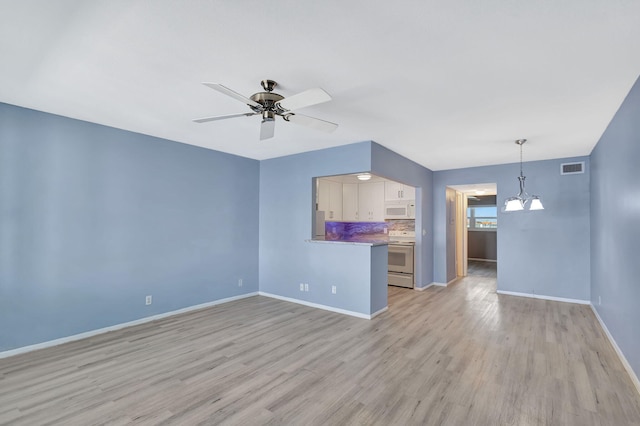 unfurnished living room with light wood-type flooring and ceiling fan with notable chandelier