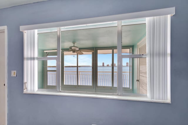 interior details with ceiling fan and a water view