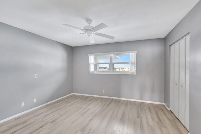 unfurnished bedroom featuring light hardwood / wood-style flooring, ceiling fan, and a closet