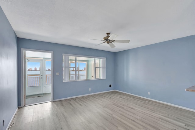 empty room with ceiling fan and light hardwood / wood-style floors