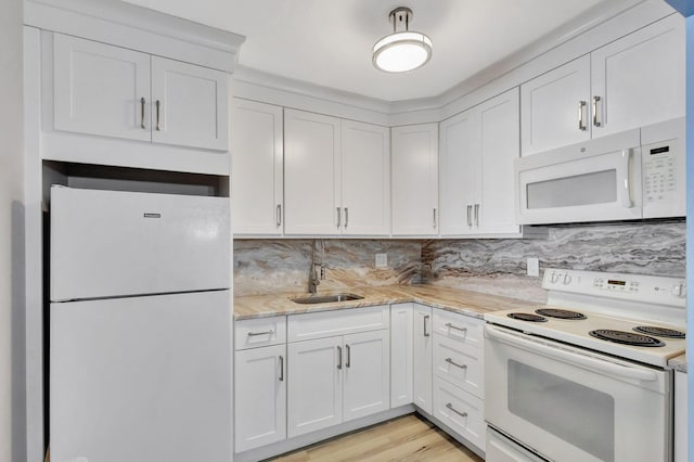 kitchen featuring white appliances, light hardwood / wood-style flooring, sink, light stone countertops, and white cabinets