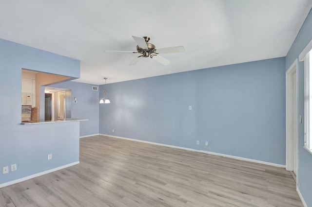 empty room with ceiling fan and light hardwood / wood-style floors