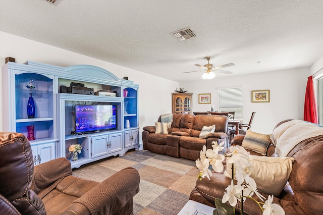 living room featuring a textured ceiling and ceiling fan