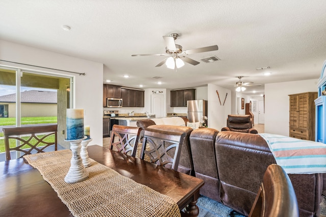 dining room with ceiling fan and a textured ceiling