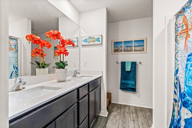 bathroom featuring hardwood / wood-style floors, a textured ceiling, and vanity