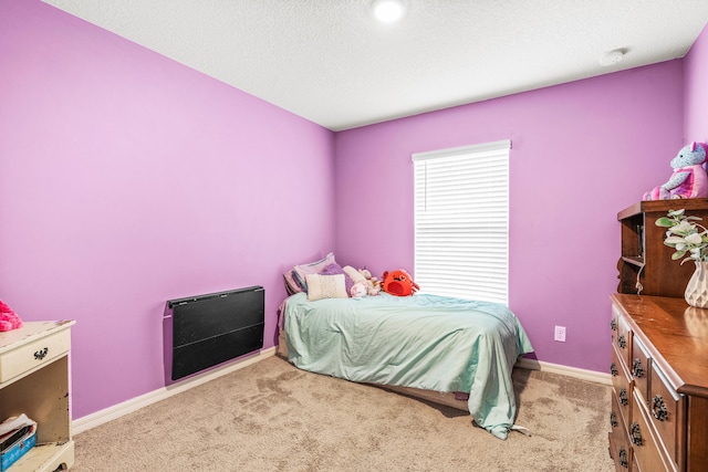 carpeted bedroom with a textured ceiling and heating unit