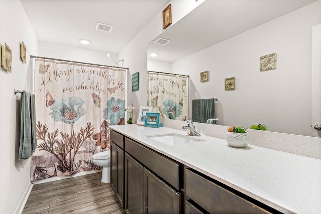 bathroom featuring walk in shower, toilet, hardwood / wood-style flooring, and vanity